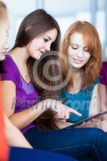 Young college students using a tablet computer in class (color toned image) Young college students using a tablet computer in class (color toned image)