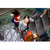 At the university/college - Students rushing up and down a busy stairway - confident pretty young female student looking upwards (color toned image)