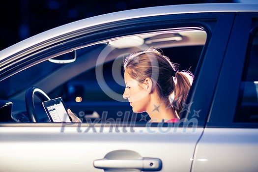 Pretty, female driver using her tablet computer (shallow DOF; color toned image) Pretty, female driver using her tablet computer (shallow DOF; color toned image)