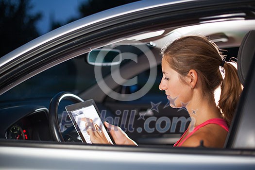 Pretty, female driver using her tablet computer (shallow DOF; color toned image) Pretty, female driver using her tablet computer (shallow DOF; color toned image)