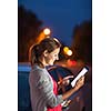 Pretty, female driver using her tablet computer (shallow DOF; color toned image)