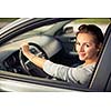 Pretty young woman driving her new car  (color toned image; shallow DOF)