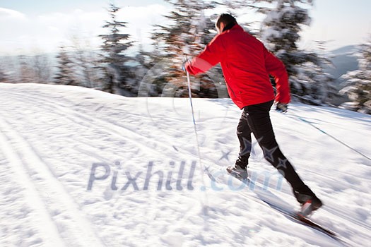 Cross-country skiing: young man cross-country skiing on a lovely sunny winter day