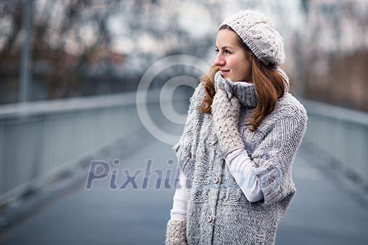 Autumn/winter portrait: young woman dressed in a warm woolen cardigan posing outside in a city park Autumn/winter portrait: young woman dressed in a warm woolen cardigan posing outside in a city park