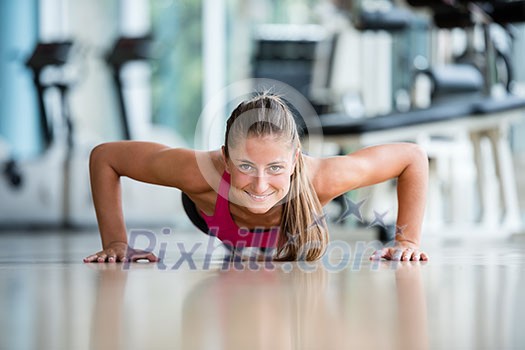 Gorgeous blonde woman warming up and doing some push ups a the gym Gorgeous blonde woman warming up and doing some push ups a the gym