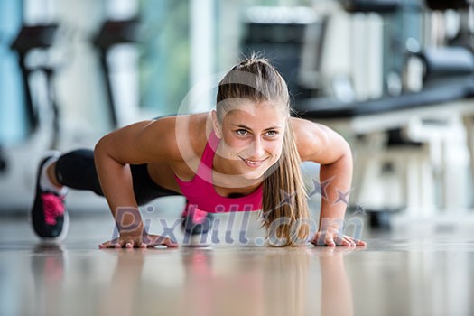 Gorgeous blonde woman warming up and doing some push ups a the gym Gorgeous blonde woman warming up and doing some push ups a the gym
