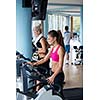Beautiful group of young women friends  exercising on a treadmill at the bright modern gym