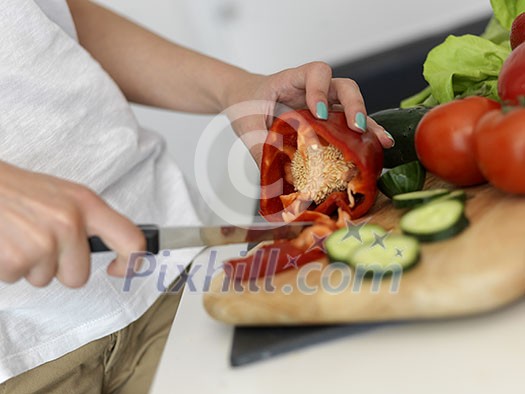 Young Woman Cooking in the kitchen. Healthy Food - Vegetable Salad. Diet. Dieting Concept. Healthy Lifestyle. Cooking At Home. Prepare Food Young Woman Cooking in the kitchen. Healthy Food - Vegetable Salad. Diet. Dieting Concept. Healthy Lifestyle. Cooking At Home. Prepare Food
