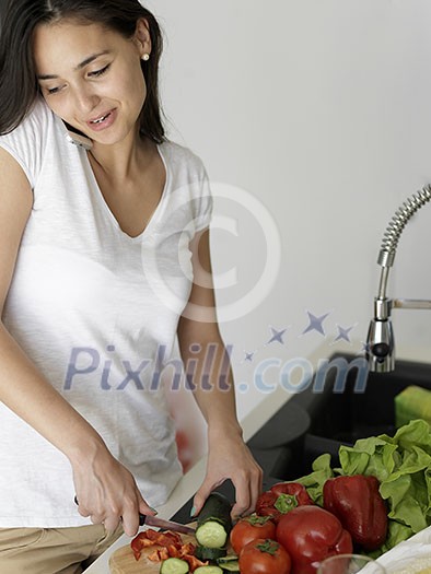 Young Woman Cooking in the kitchen. Healthy Food - Vegetable Salad. Diet. Dieting Concept. Healthy Lifestyle. Cooking At Home. Prepare Food Young Woman Cooking in the kitchen. Healthy Food - Vegetable Salad. Diet. Dieting Concept. Healthy Lifestyle. Cooking At Home. Prepare Food