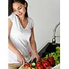 Young Woman Cooking in the kitchen. Healthy Food - Vegetable Salad. Diet. Dieting Concept. Healthy Lifestyle. Cooking At Home. Prepare Food