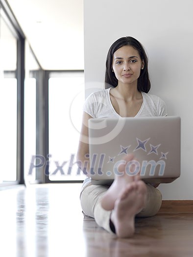 beautiful young woman relax and work on laptop computer modern home office while listening musin on white headphones beautiful young woman relax and work on laptop computer modern home office while listening musin on white headphones