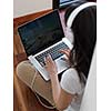 beautiful young woman relax and work on laptop computer modern  home office while listening musin on white headphones