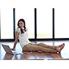 beautiful young woman relax and work on laptop computer modern  home office while listening musin on white headphones