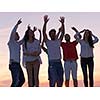group of happy young people dancing and have fun on party in modern home bacony with sunset and ocean in background