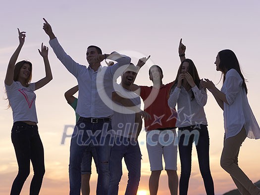 group of happy young people dancing and have fun on party in modern home bacony with sunset and ocean in background group of happy young people dancing and have fun on party in modern home bacony with sunset and ocean in background
