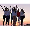 group of happy young people dancing and have fun on party in modern home bacony with sunset and ocean in background