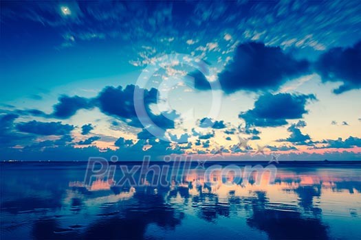 Vintage retro hipster style travel image of tropical vacation holidays concept background - Sunset on Baga beach. Goa, India Vintage retro hipster style travel image of tropical vacation holidays concept background - Sunset on Baga beach. Goa, India