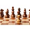 One pawn agains all - wooden chess pieces on chessboard. Selective focus, shallow depth of field