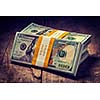 Creative business finance making money concept. Vintage retro effect filtered hipster style image of stacks of new 100 US dollars 2013 edition banknotes bills bundles isolated on wooden background