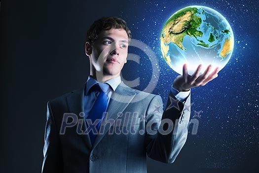 Young businessman holding Earth planet in palm. Elements of this image are furnished by NASA Young businessman holding Earth planet in palm. Elements of this image are furnished by NASA
