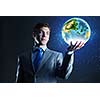 Young businessman holding Earth planet in palm. Elements of this image are furnished by NASA
