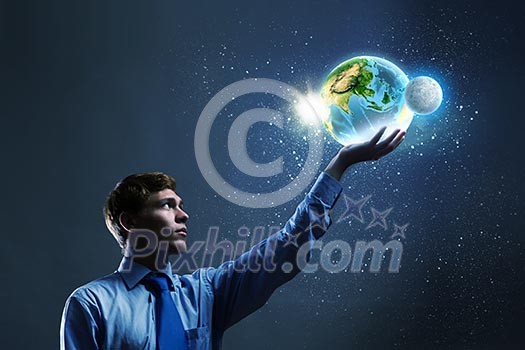 Young businessman holding Earth planet in palm. Elements of this image are furnished by NASA Young businessman holding Earth planet in palm. Elements of this image are furnished by NASA