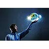 Young businessman holding Earth planet in palm. Elements of this image are furnished by NASA