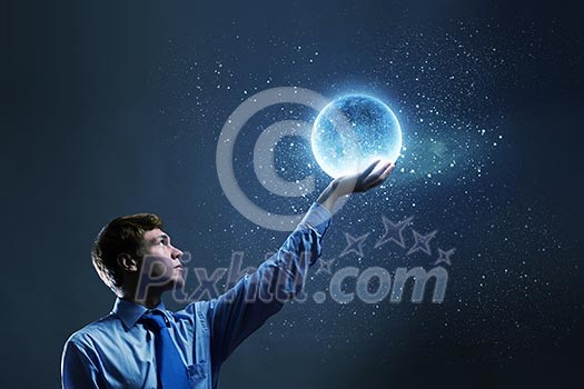 Young man in suit holding moon in palm Young man in suit holding moon in palm
