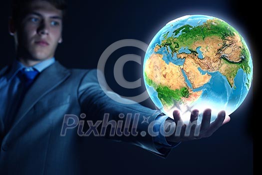 Young businessman holding Earth planet in palm. Elements of this image are furnished by NASA Young businessman holding Earth planet in palm. Elements of this image are furnished by NASA