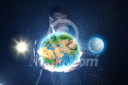 Young businessman holding Earth planet in palm. Elements of this image are furnished by NASA Young businessman holding Earth planet in palm. Elements of this image are furnished by NASA
