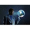 Young businessman holding Earth planet in palm. Elements of this image are furnished by NASA