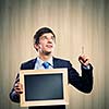 Handsome businessman holding wooden blank frame. Place for text