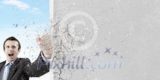 Businessman breaking stone wall with karate punch Businessman breaking stone wall with karate punch