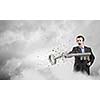 Angry businessman crashing stone key with punch