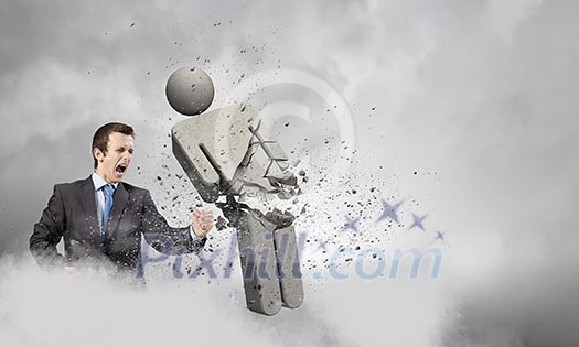 Angry young businessman fighting with stone opponent Angry young businessman fighting with stone opponent