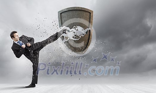 Businessman breaking stone shield with karate punch Businessman breaking stone shield with karate punch