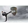 Businessman breaking stone shield with karate punch