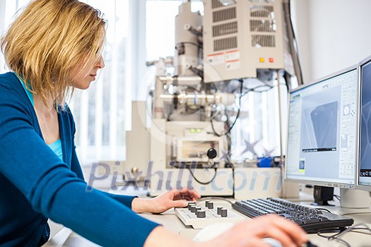Pretty, female researcher using a microscope in a lab, doing research (color toned image) Pretty, female researcher using a microscope in a lab, doing research (color toned image)