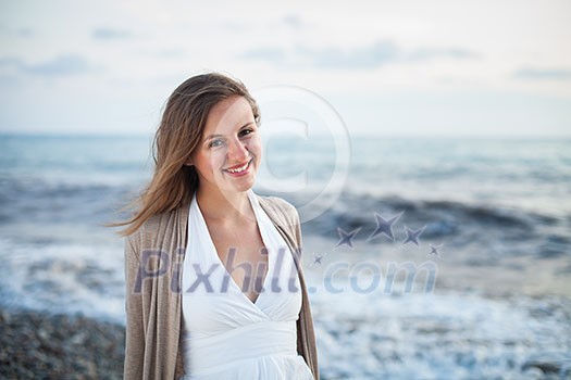 Young woman on the beach enjoying a warm summer evening on the seacoast Young woman on the beach enjoying a warm summer evening on the seacoast