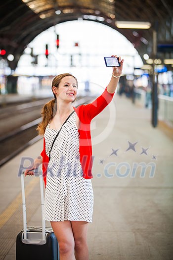 Pretty young woman at a train station - taking a selfie with her smart phone Pretty young woman at a train station - taking a selfie with her smart phone