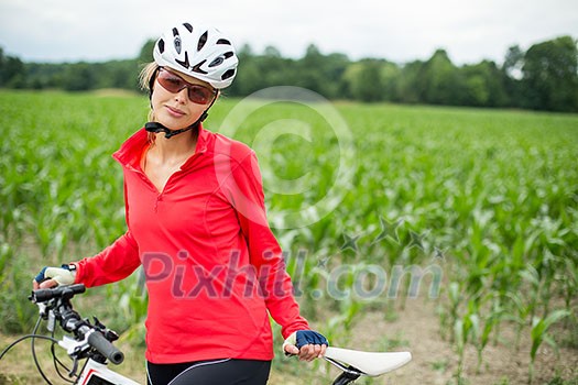 Pretty, young female biker outdoors on her mountain bike (shallow DOF; selective focus) Pretty, young female biker outdoors on her mountain bike (shallow DOF; selective focus)