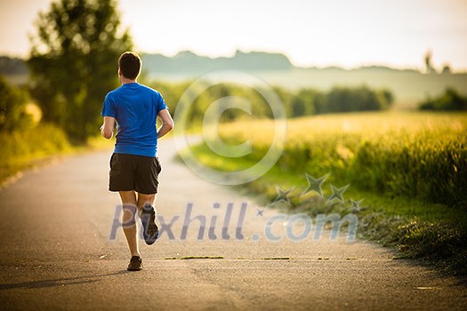 Male athlete/runner running on road - jog workout well-being concept