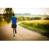 Male athlete/runner running on road - jog workout well-being concept