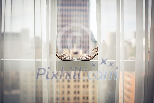 Lovely fashionable shoes of a bride on a window during wedding day preparations Lovely fashionable shoes of a bride on a window during wedding day preparations