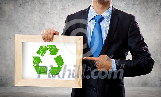 Close up of businessman holding frame with recycle sign Close up of businessman holding frame with recycle sign