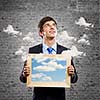 Handsome young man holding frame with pictures