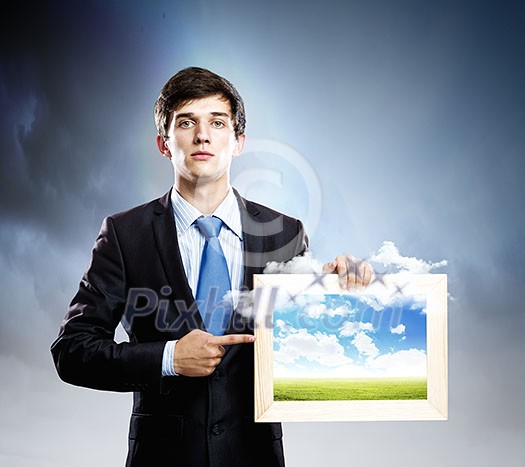 Handsome young man holding frame with pictures Handsome young man holding frame with pictures