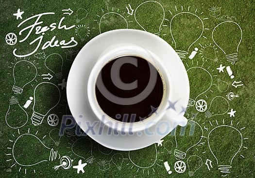 Close up of cup of coffee on table with sketches on background Close up of cup of coffee on table with sketches on background