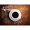 Close up of cup of coffee on table with sketches on background