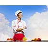 Young cheerful cook and ingredients flying in air